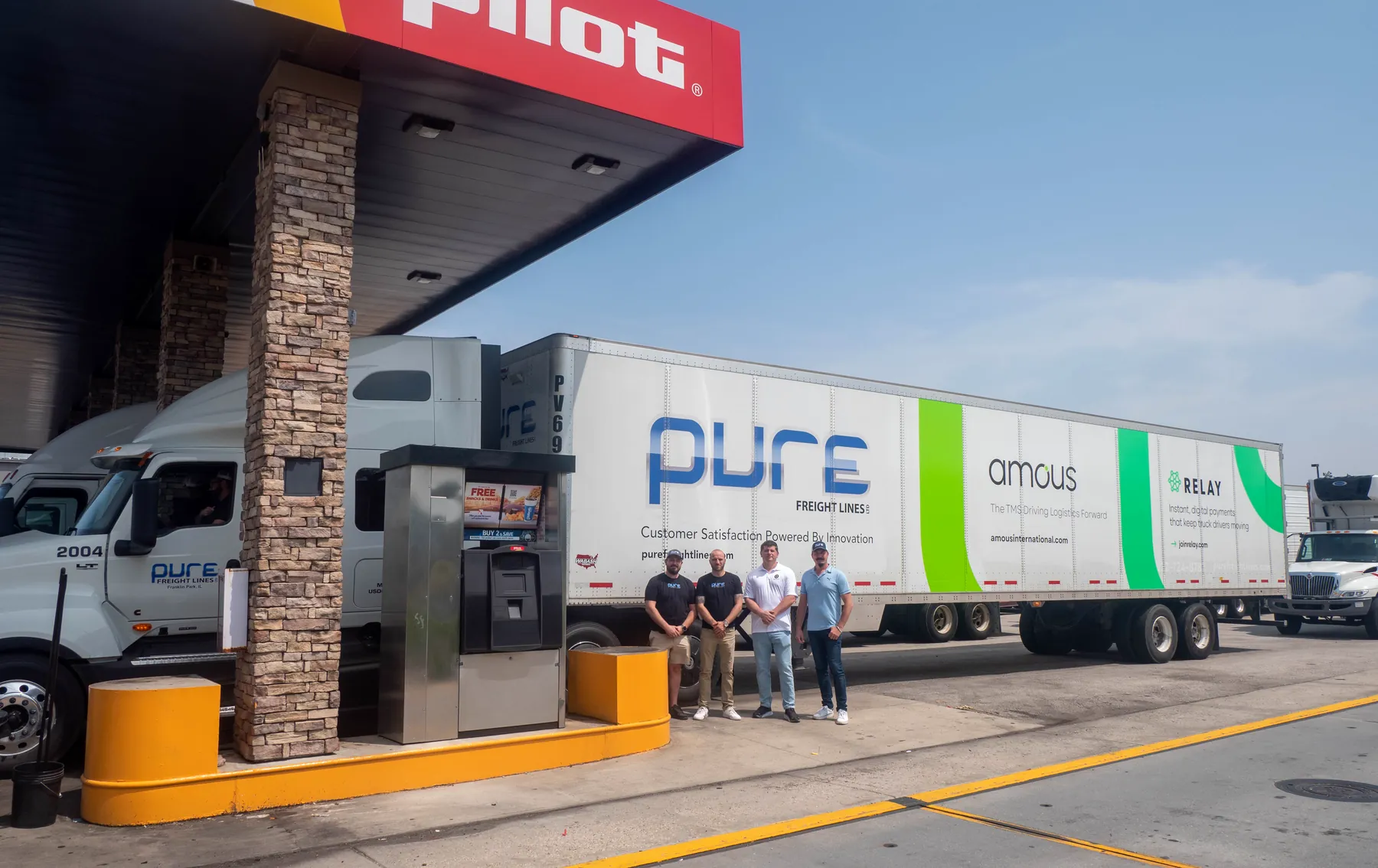 The Pure team at a Pilot fuel island in front of a Pure trailer